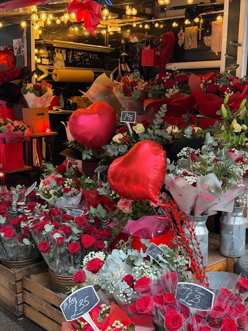 A vibrant display of fresh flowers arranged in brown wrapping paper, including green tulips, purple carnations, orange roses, white lilacs, and pink carnations, placed in metallic buckets. The flowers